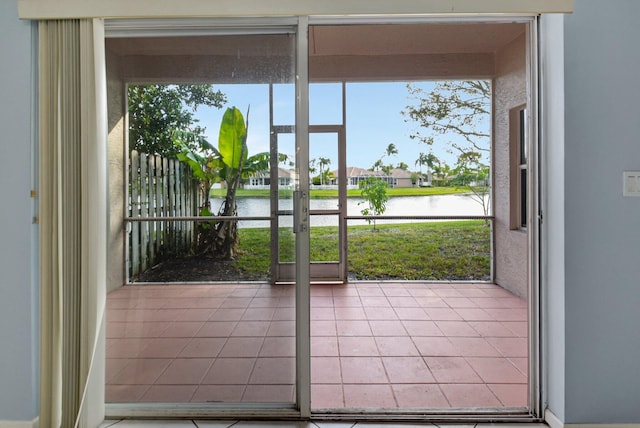 doorway to outside featuring a healthy amount of sunlight and a water view