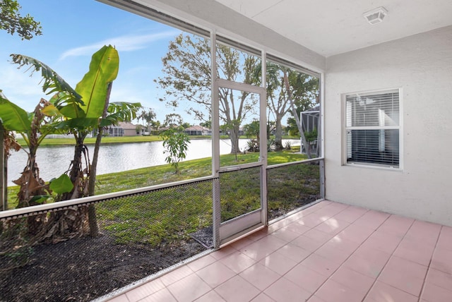 unfurnished sunroom featuring a water view