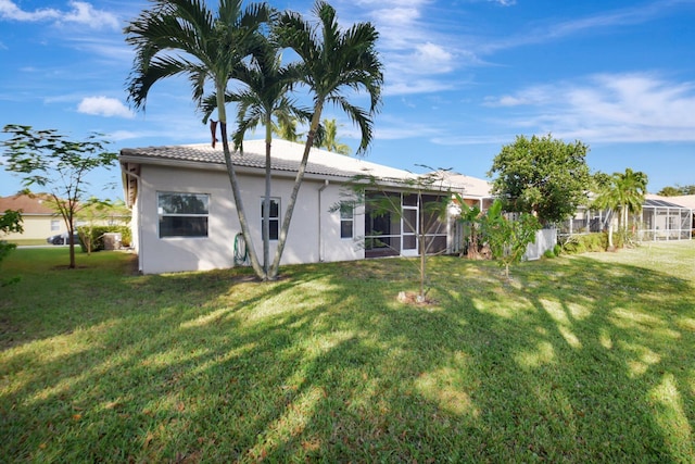 back of house featuring a sunroom and a yard