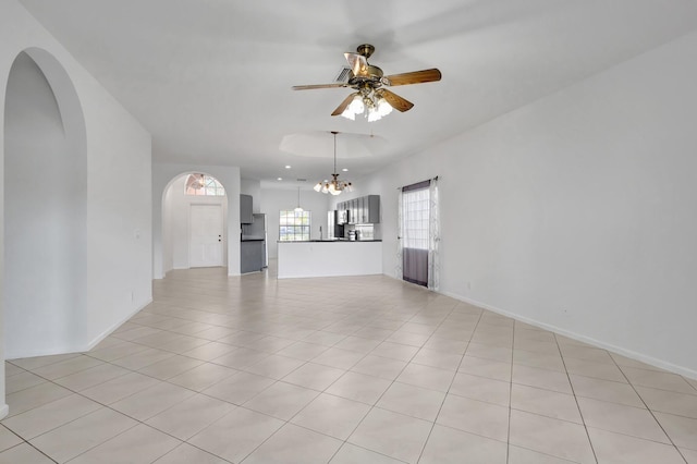 8620 Pine Cay, West Palm Beach, FL 33411 - unfurnished living room featuring a ceiling fan, a chandelier, arched walkways, light tile patterned flooring, and baseboards