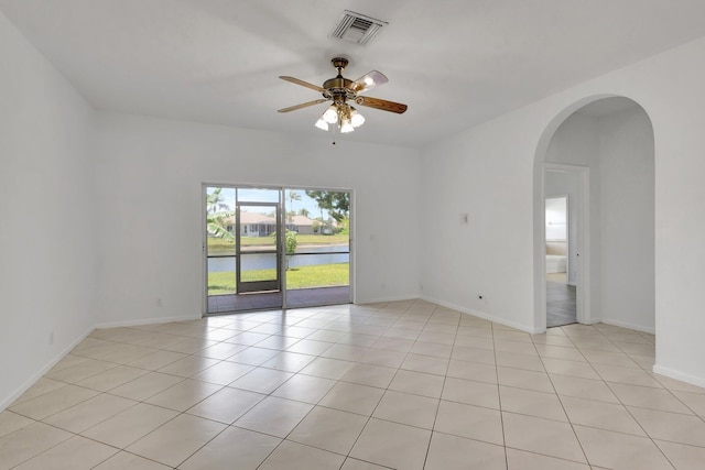 8620 Pine Cay, West Palm Beach, FL 33411 - spare room featuring a ceiling fan, arched walkways, a water view, and light tile patterned flooring