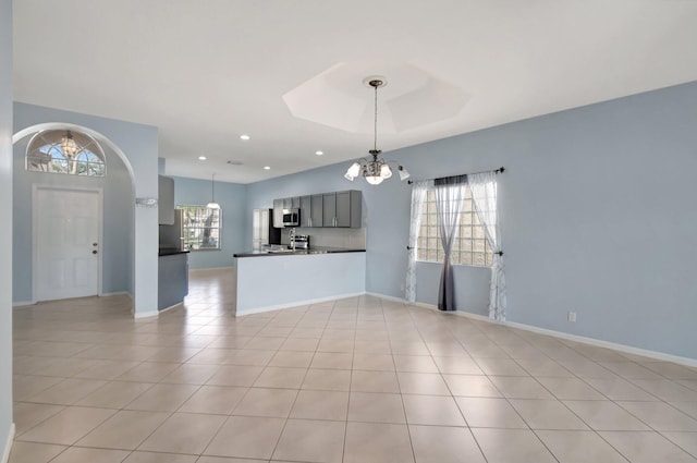 interior space with gray cabinetry, hanging light fixtures, kitchen peninsula, a chandelier, and light tile patterned floors