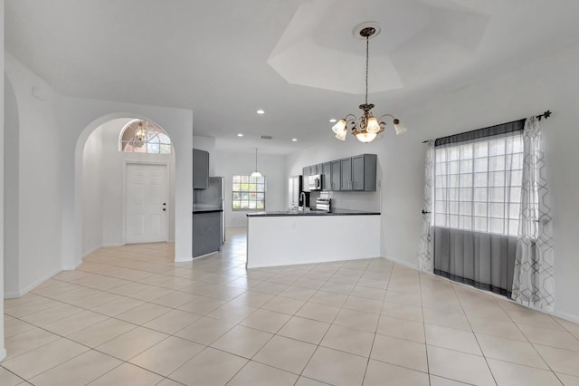 8620 Pine Cay, West Palm Beach, FL 33411 - unfurnished living room featuring a chandelier, light tile patterned flooring, arched walkways, baseboards, and recessed lighting