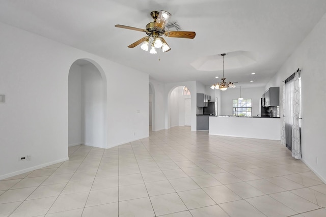 8620 Pine Cay, West Palm Beach, FL 33411 - unfurnished living room featuring arched walkways, a ceiling fan, a chandelier, light tile patterned floors, and baseboards