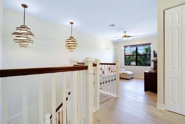 hallway featuring light wood-type flooring and a notable chandelier