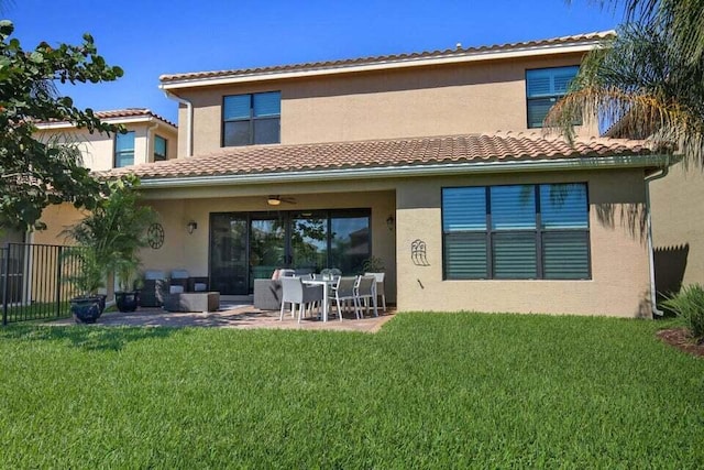 rear view of house featuring ceiling fan, a yard, a patio, and an outdoor hangout area