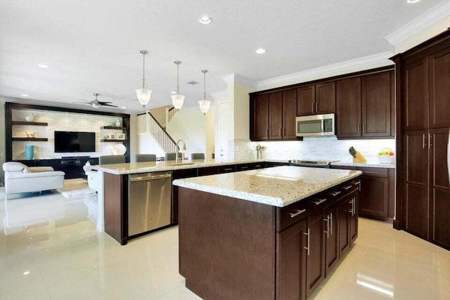 kitchen with sink, ceiling fan, appliances with stainless steel finishes, decorative light fixtures, and kitchen peninsula