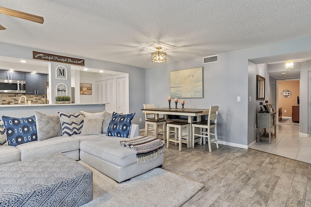 living room featuring light hardwood / wood-style floors and a textured ceiling