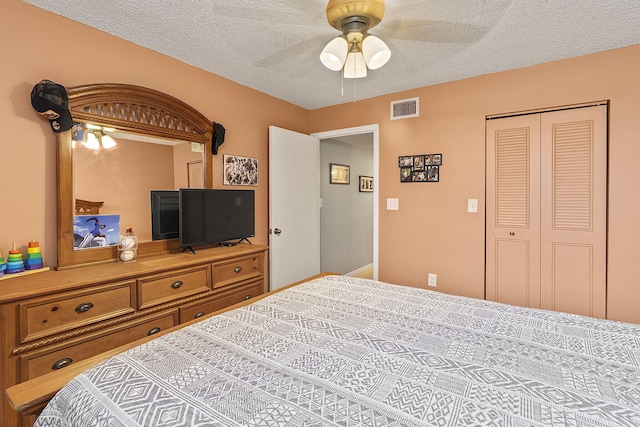 bedroom featuring a textured ceiling, a closet, ceiling fan, and visible vents