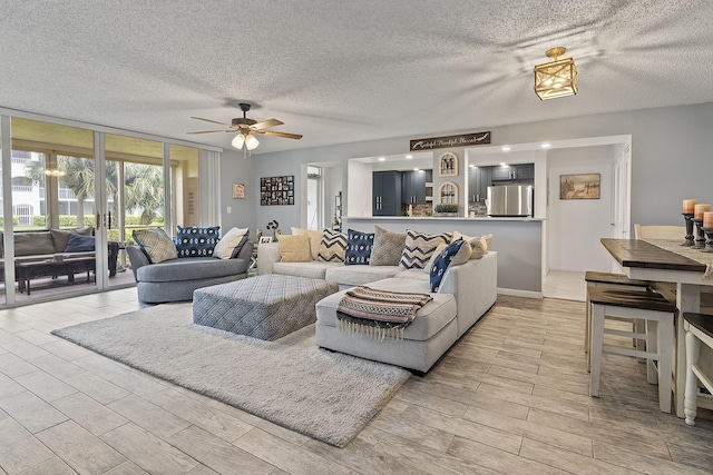 living room with ceiling fan, floor to ceiling windows, and a textured ceiling