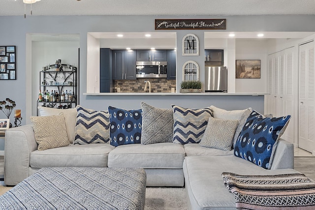 living room featuring sink and a textured ceiling