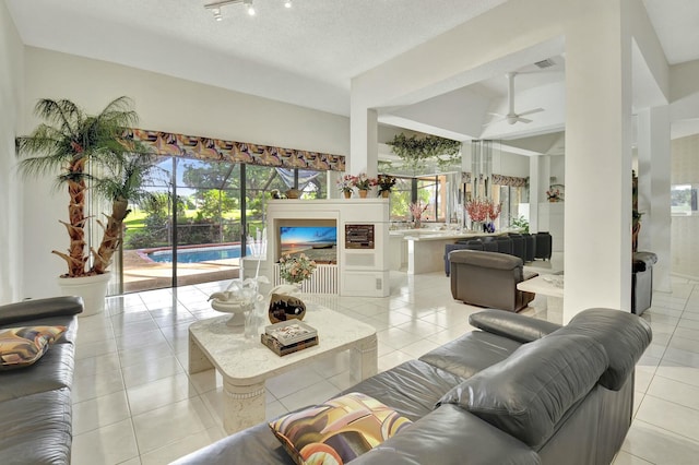 living room with light tile patterned floors, a textured ceiling, plenty of natural light, and ceiling fan