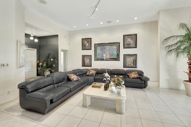 living room with light tile patterned flooring, a high ceiling, and track lighting