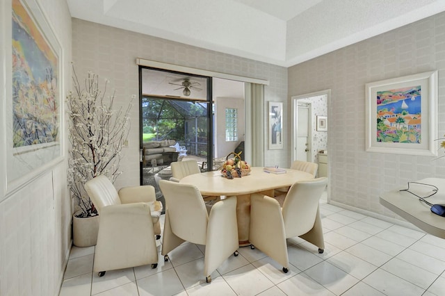 tiled dining area with a raised ceiling