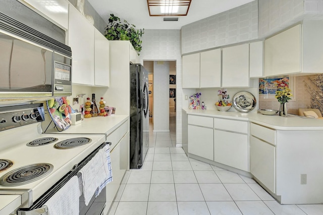 kitchen with white cabinets, black appliances, and light tile patterned floors