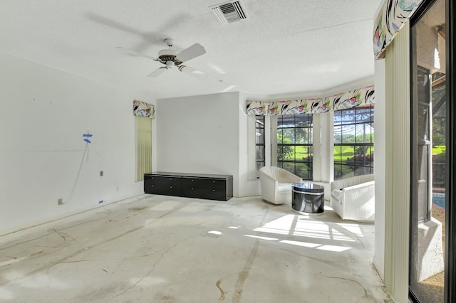 interior space featuring ceiling fan, concrete floors, and a textured ceiling