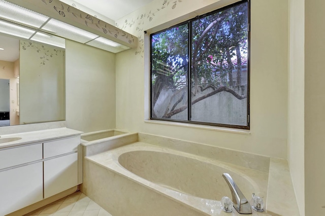 bathroom with tile patterned floors, a bathing tub, and vanity