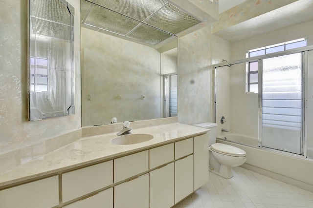 full bathroom featuring vanity, bath / shower combo with glass door, and toilet