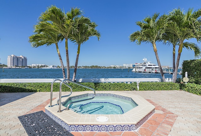 view of pool with a community hot tub and a water view