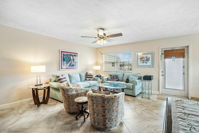 living room featuring ceiling fan and a textured ceiling