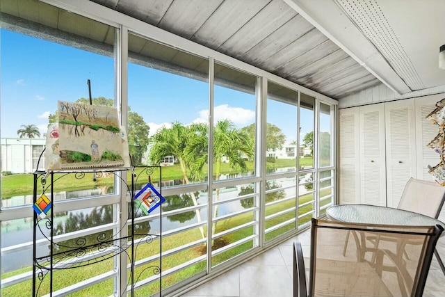 sunroom / solarium featuring a water view