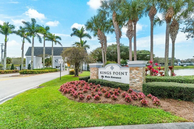 community / neighborhood sign with a yard and a water view