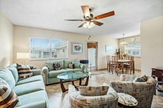 living room with a textured ceiling, plenty of natural light, and ceiling fan