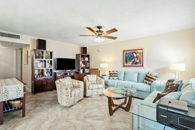 living room with ceiling fan and a textured ceiling