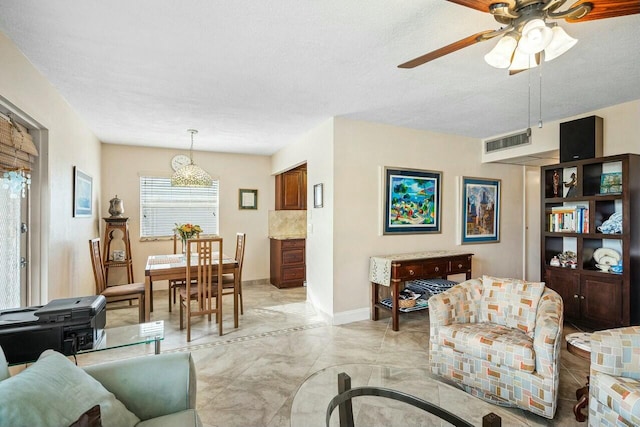 living room with ceiling fan and a textured ceiling