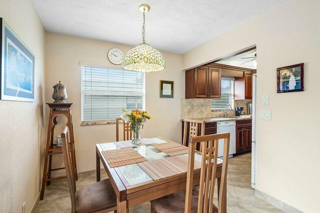 dining area with a textured ceiling, ceiling fan, a healthy amount of sunlight, and sink