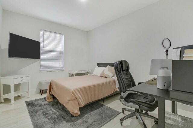 laundry area with light hardwood / wood-style floors and stacked washing maching and dryer