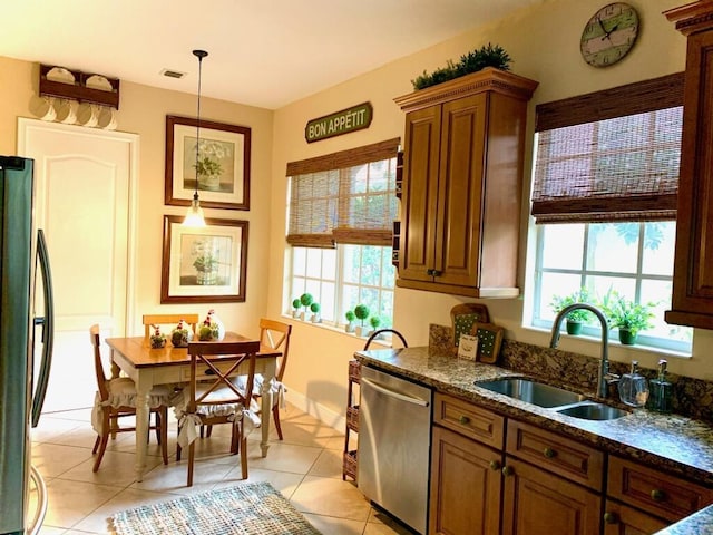 kitchen with plenty of natural light, sink, decorative light fixtures, and appliances with stainless steel finishes