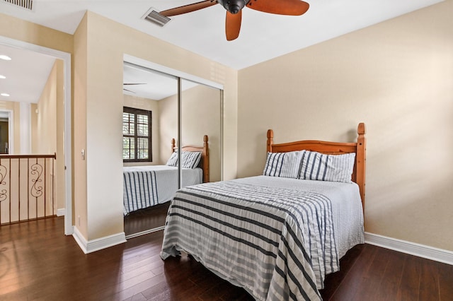 bedroom with a closet, dark wood-type flooring, and ceiling fan