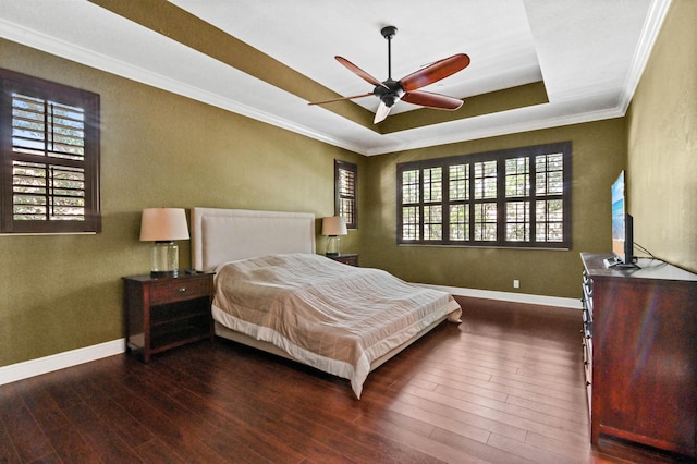 bedroom featuring hardwood / wood-style floors, a raised ceiling, ceiling fan, and ornamental molding