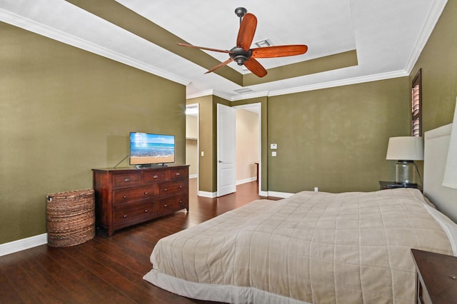 bedroom with ornamental molding, a tray ceiling, ceiling fan, and dark wood-type flooring