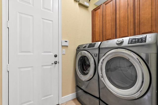 washroom with cabinets, independent washer and dryer, and light tile patterned floors