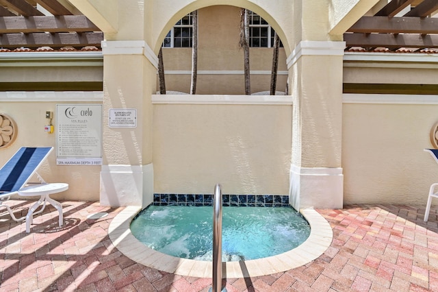 view of pool with a hot tub