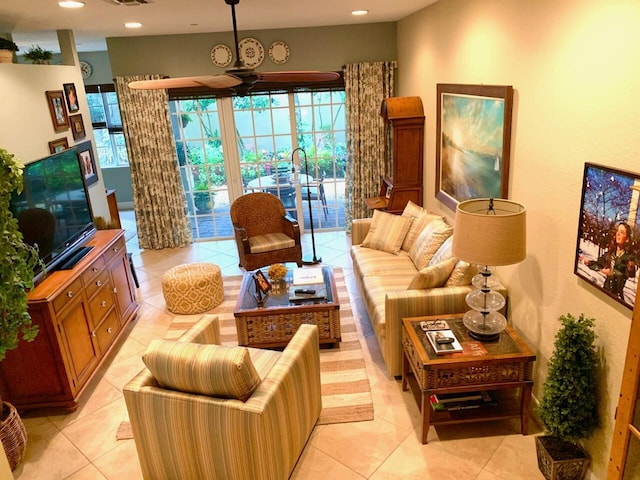 living room featuring ceiling fan, light tile patterned floors, and a healthy amount of sunlight