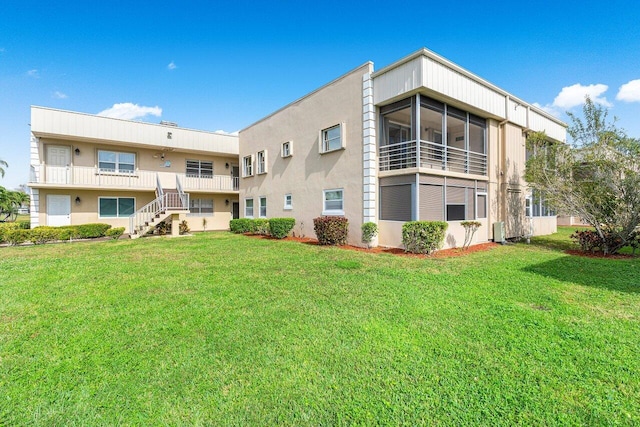 back of property featuring central AC unit and a yard