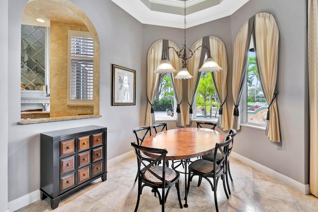 dining room featuring a chandelier, a tray ceiling, and ornamental molding