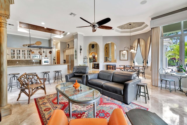 living room with ceiling fan with notable chandelier, a raised ceiling, and ornamental molding