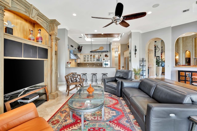 tiled living room featuring ceiling fan and ornamental molding