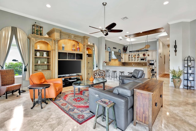 living room featuring a tray ceiling, ceiling fan, and ornamental molding