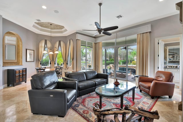 living room featuring ceiling fan with notable chandelier, a raised ceiling, and ornamental molding