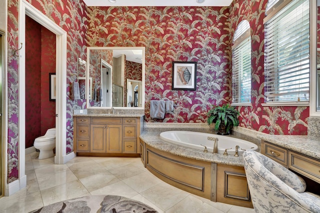 bathroom with tile patterned floors, vanity, toilet, and a bathing tub