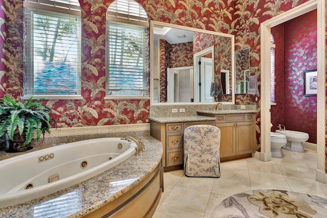 bathroom featuring vanity, a bidet, tile patterned floors, toilet, and a tub to relax in