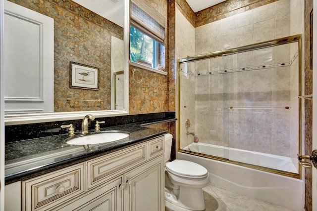 full bathroom with tile patterned flooring, toilet, vanity, and combined bath / shower with glass door