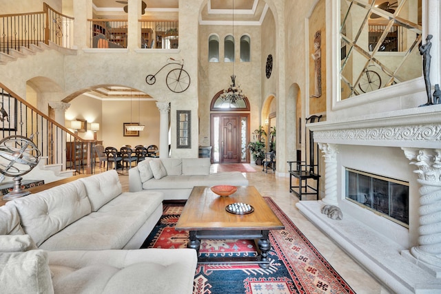 living room featuring ornate columns, crown molding, and a high ceiling