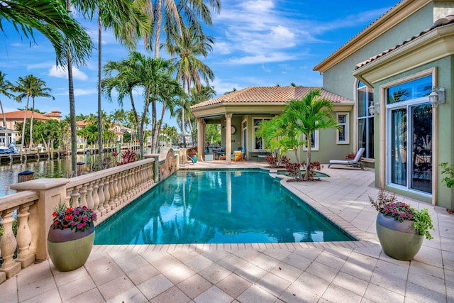 view of swimming pool featuring a water view and a patio area