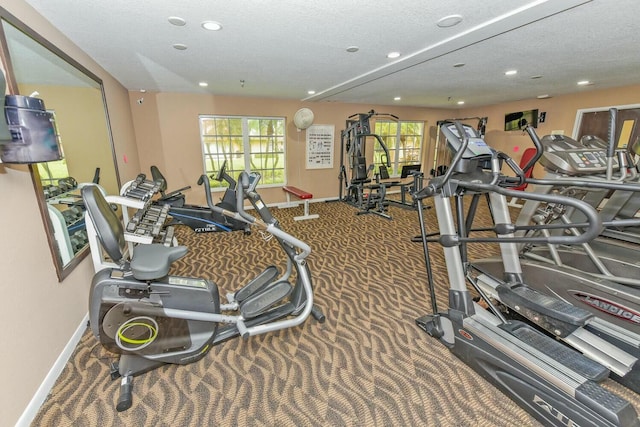 exercise room with carpet and a textured ceiling